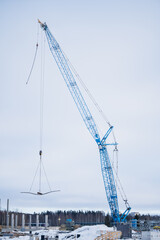 Fototapeta premium Blue construction crane lifting cement blocs