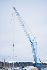 Fototapeta premium Blue construction crane lifting cement blocs
