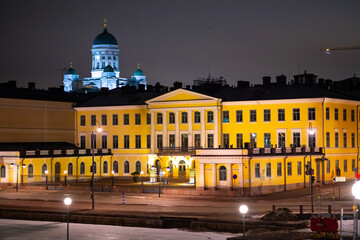 Helsinki Presidential palace during night-time with Helsinki cathedral shining in the background