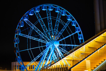 Blue colour illuminated Ferris wheel attraction in Helsinki, Finland during night time
