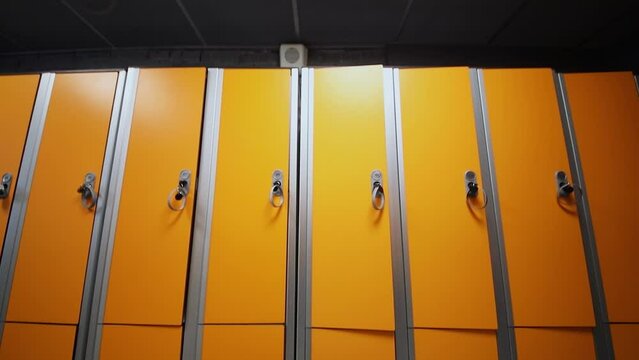 Bench is near rows of lockers in dressing room of fitness center