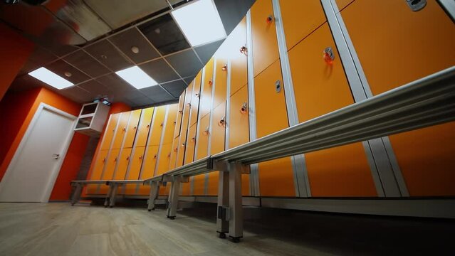 Locker room with benches and rows of boxes in sports center