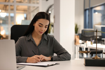 Portrait of confident lawyer working at table in office