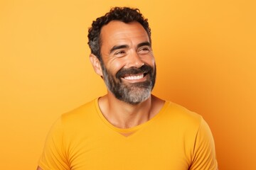 Portrait of happy mature man in yellow t-shirt on yellow background