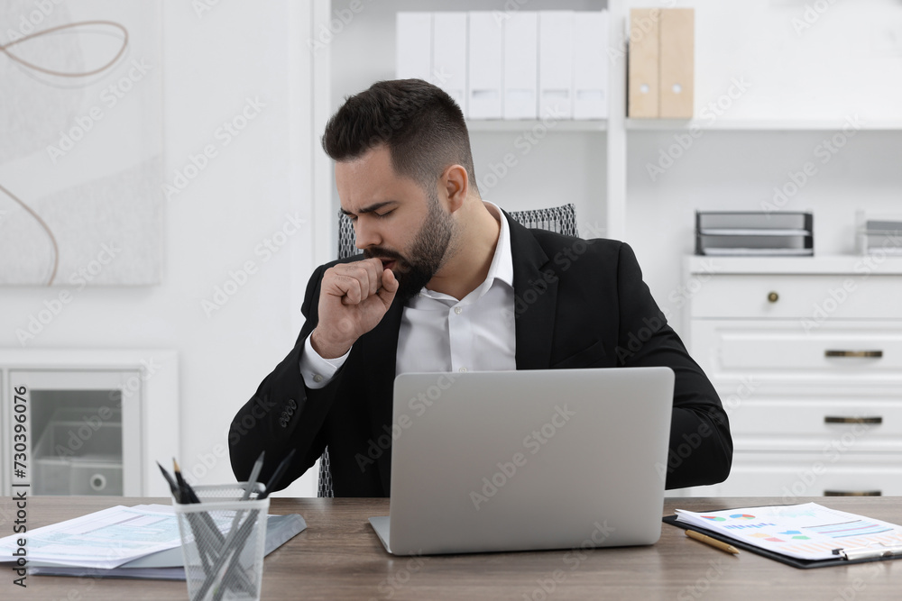 Wall mural Sick man coughing at workplace in office