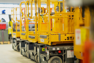 Yellow close up image photo of yellow construction lifts in line