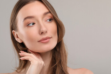 Beautiful woman with healthy skin on gray background, space for text