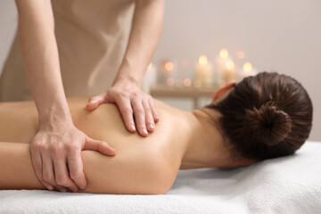 Obraz na płótnie Canvas Woman receiving back massage on couch in spa salon