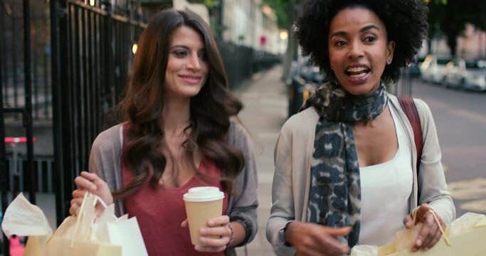 Women friends, shopping bag and coffee in street, conversation and happy together on metro sidewalk. Girl, retail sale and smile with drink, tea cup and discussion with gift in city, road and chat