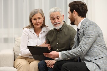 Notary consulting senior couple about Last Will and Testament in office