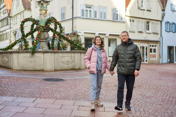 Loving couple of tourists walking around old town. Couple of lovers leisurely stroll in the cool...