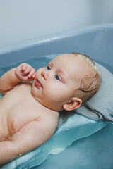 Caring for a newborn baby, bathing the baby. Bathing a baby in a bathtub. Baby's first baths