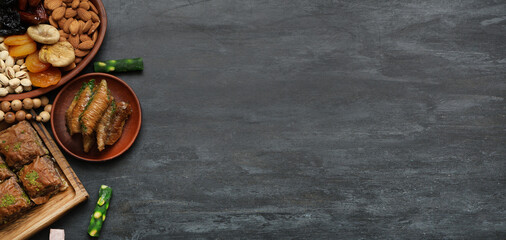 Different Eastern sweets on dark background with space for text, top view. Ramadan celebration