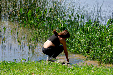 Girl with her sportswear plays in the lake.