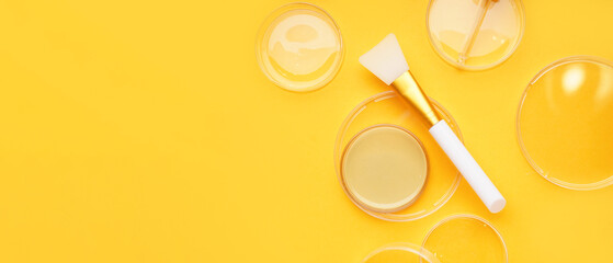 Petri dishes with sample and makeup brush on yellow background with space for text