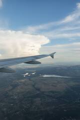 View from the airplane window, clouds, land, and sky