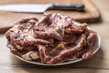 Salted and spiced pork neck ready for baking or grilling.