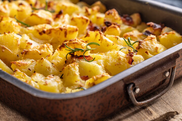 Baked crispy potatoes with rosemary in an old baking dish