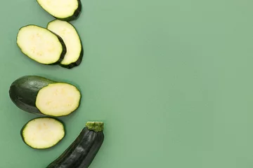 Fototapeten Slices of fresh zucchini on green background © Pixel-Shot
