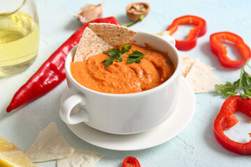 Pot of tasty muhammara and ingredients on white background