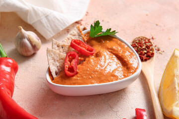 Bowl of tasty muhammara on beige background