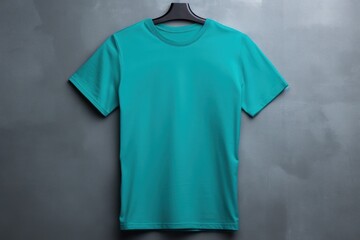 Turquoise t shirt is seen against a gray wall