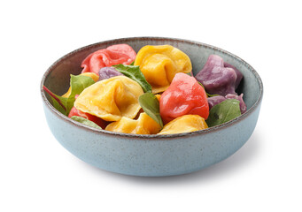 Bowl with boiled colorful dumplings and spinach on white background