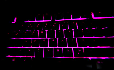 Gaming PC Keyboard illuminated pink color and dark black background