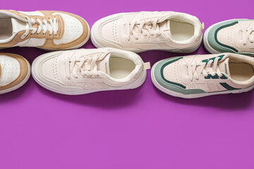Different stylish sneakers on purple background