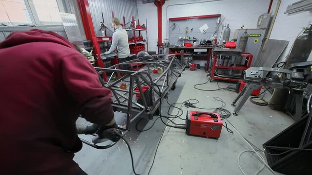  (PR) Worker grinds carcase of sport car in workshop of DB 527 company