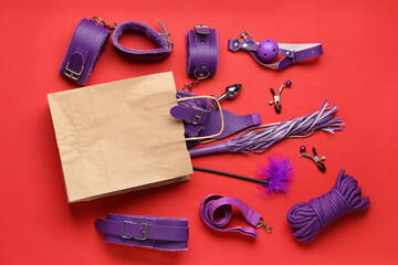 Shopping bag with sex toys on red background