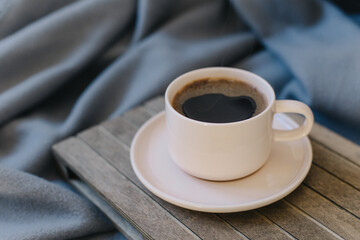 Cup of black coffee in a pink pastel ceramic cup on a grey background.