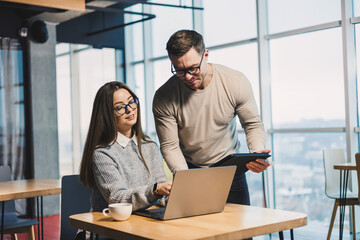 Working day in a modern office with workers in casual clothes, male and female colleagues working...