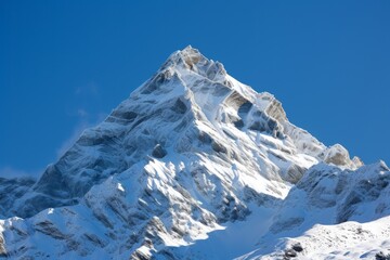 A snowy mountain peak under a clear blue winter sky