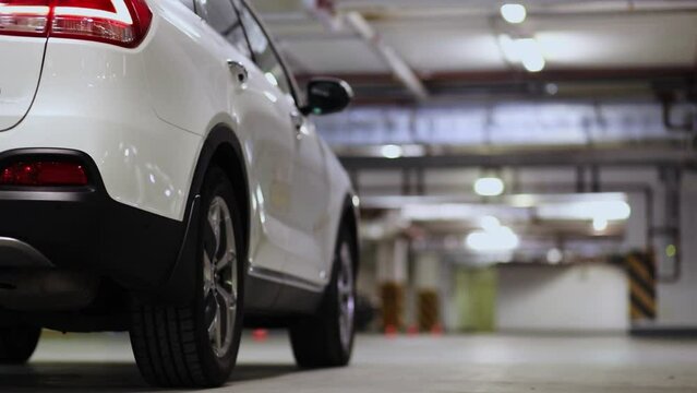 Rear wheel of white car which stand on underground parking