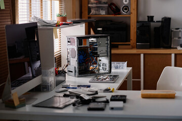 Workplace in modern workshop with disassembled system unit of computer placed on table