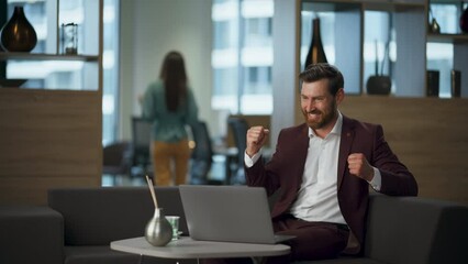 Surprised entrepreneur rejoicing victory feeling success at workplace interior