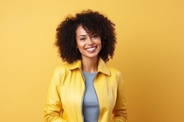Obraz na płótnie Canvas Portrait of beautiful african american woman in yellow jacket over yellow background