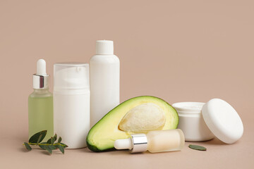 Obraz na płótnie Canvas Set of different cosmetic products and avocado on color background