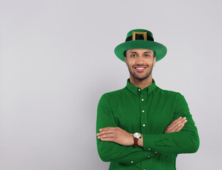 St. Patrick's day party. Man with green leprechaun hat on grey background. Space for text