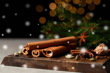 Different spices and fir tree branches on grey table, closeup. Cinnamon, anise, cardamom, cloves,...