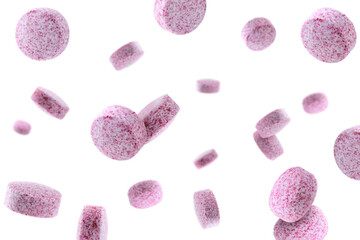 Vitamin. Pink tablets falling on white background
