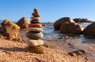 Zen like stones. Zen stones stacked on a beach. Peace buddhism meditation symbol. Relaxation. Flat stones stacked at the edge of a beach, swathed by the water waves.	
