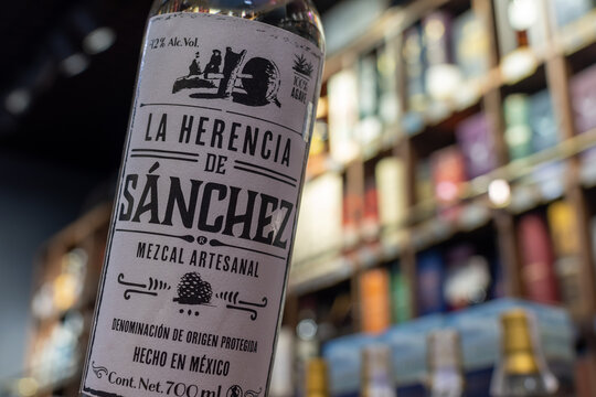 Bottle of Mexican mezcal artesanal La Herencia de Sanchez close-up on blurred background of wine shelves. Ukraine, Zhytomyr, February, 7, 2024