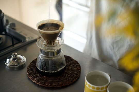 コーヒー、珈琲、ハンドドリップ、ドリップ、淹れる、コーヒーカップ、珈琲器具、コーヒー器具、ドリッパー、ペーパードリップ、お湯、マグカップ、キッチン、ライフスタイル、屋内、室内、コピースペース、テキストスペース、おしゃれ、かっこいい、渋い、空間、センス、インテリア、インテリア好き、雑貨、雑貨好き、ホットコーヒー、飲み物、ポット、手元、手、顔なし、タカヒロポット、KONO、コーノ式、コーノドリッパー、