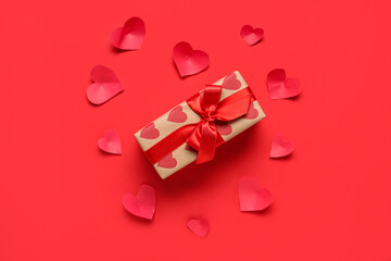 Composition with gift box and paper hearts on red background. Valentines Day celebration