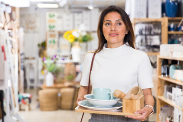 Portrait of positive young woman at shopping at home accessories store