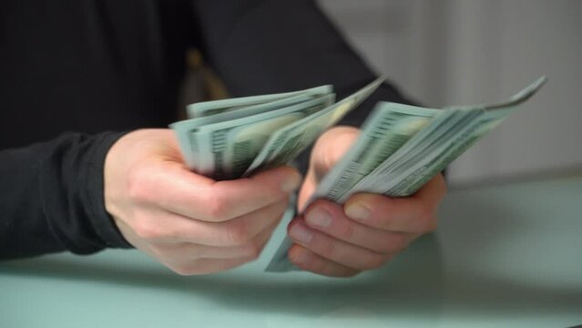 4K close up footage of female hands counting 100 dollar banknotes.