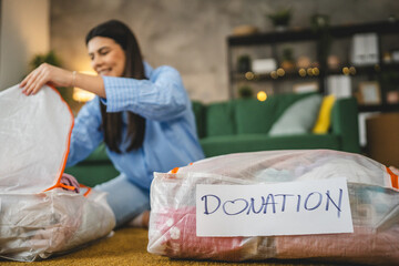 One woman caucasian adult at home choose clothes for charity donation