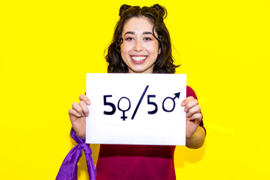 Exuberant Woman Championing Gender Balance with "50/50" Sign